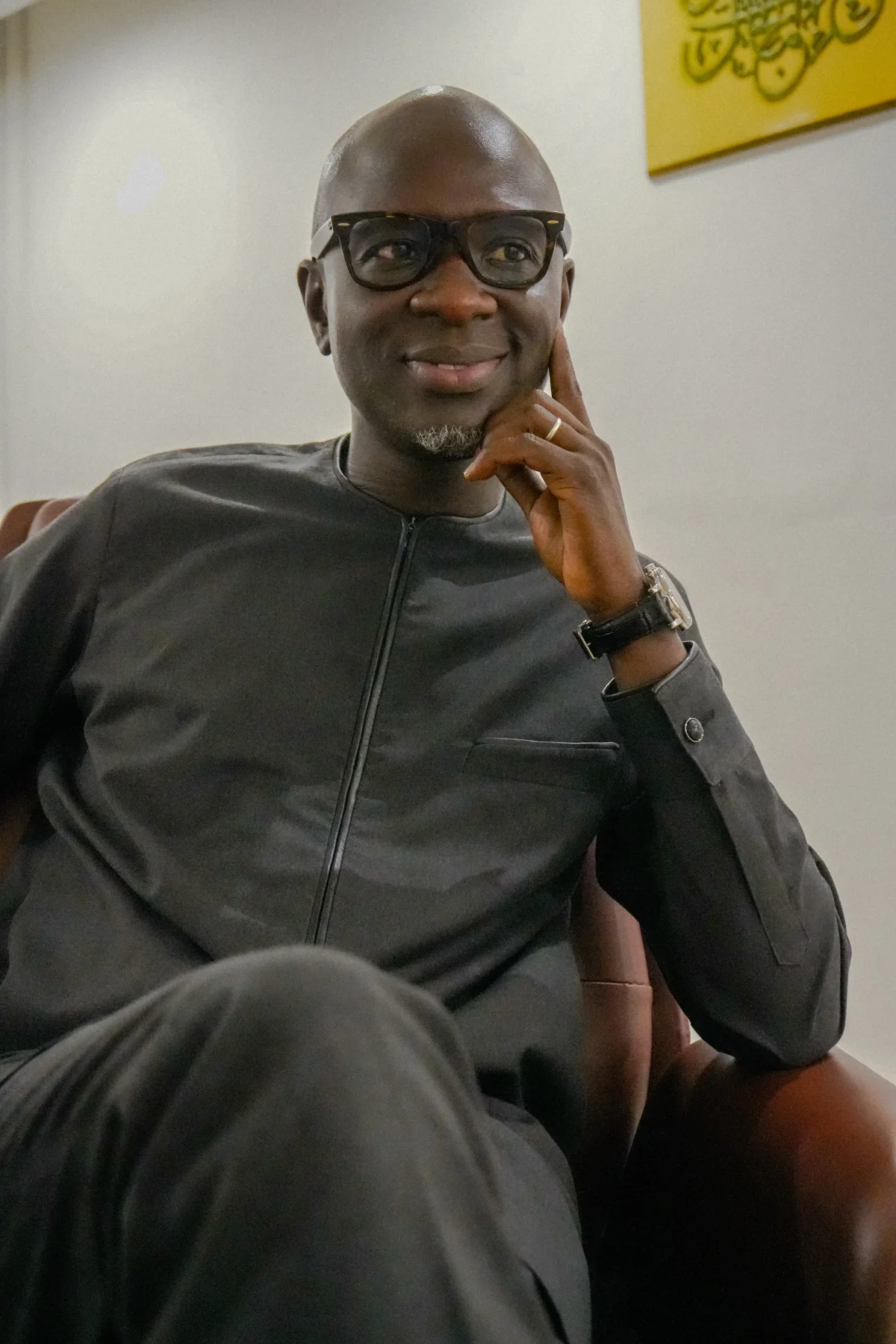 Alassane Mbaye assis, souriant